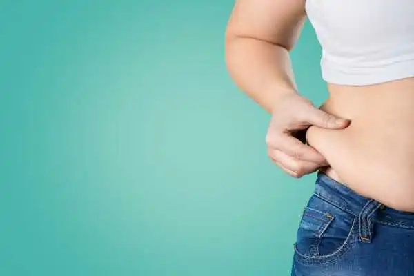 Image of woman pinching her love handles to show weight gain Banstead