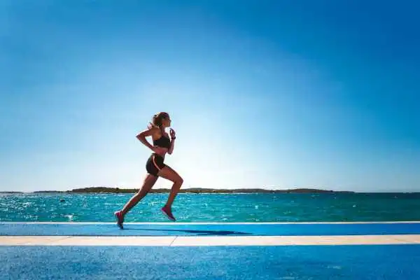 Woman running showing strong leg muscle Banstead